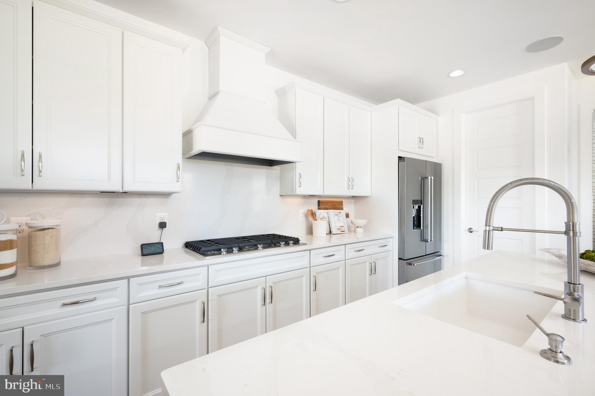 42108 Creighton Road Ashburn, VA 20148 - Photo 10 of 39 a kitchen with white cabinets and white appliances