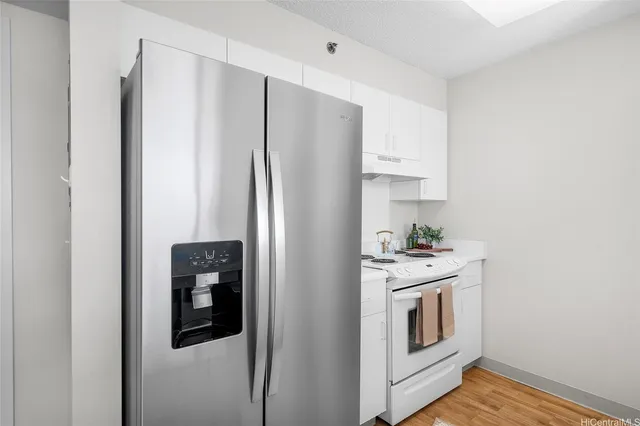 a kitchen with stainless steel appliances white cabinets and a refrigerator