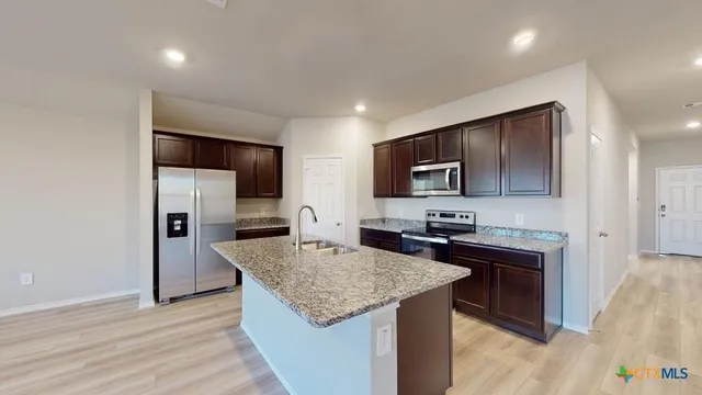 a kitchen with granite countertop cabinets stainless steel appliances and a counter space
