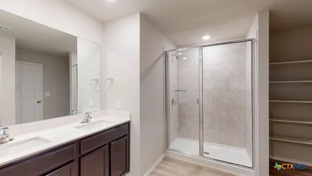 a bathroom with a shower sink vanity and mirror