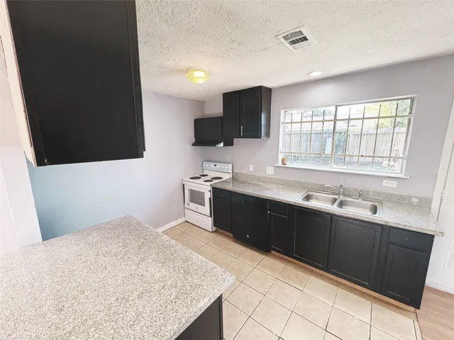 a kitchen with a sink window and refrigerator