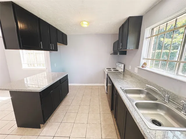 a kitchen with a sink stove top oven and cabinets