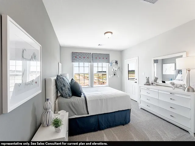 a bedroom with a large bed and windows