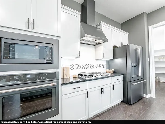 a kitchen with stainless steel appliances a stove a refrigerator and cabinets