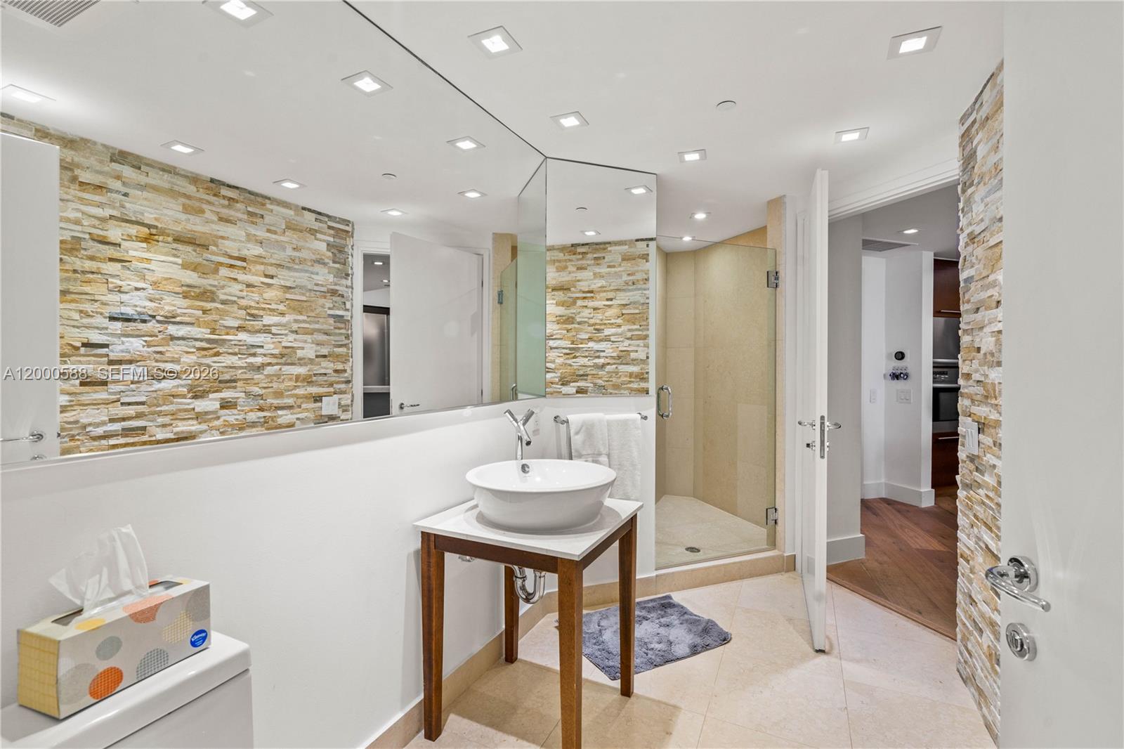 450 Alton Road, Unit 806 Miami Beach, FL 33139 - Photo 15 of 23 a bathroom with a granite countertop sink a toilet a mirror and shower