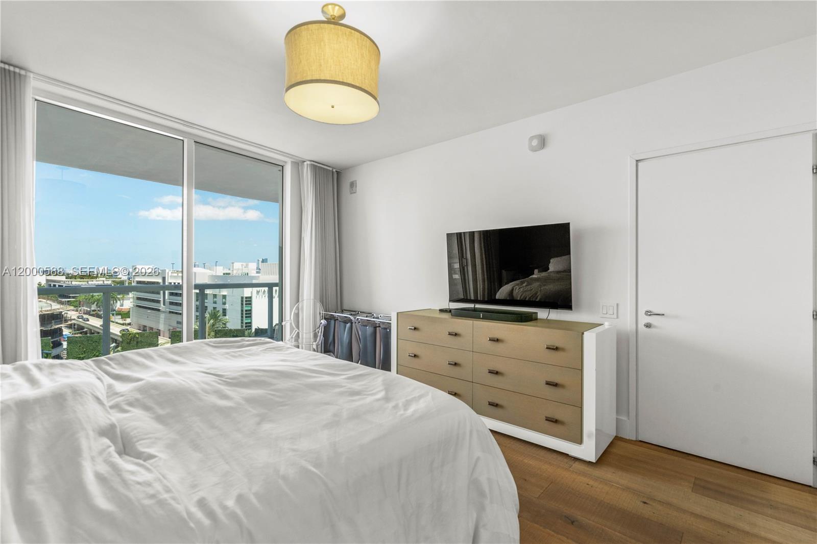 450 Alton Road, Unit 806 Miami Beach, FL 33139 - Photo 17 of 23 a bedroom with a bed and wooden floor