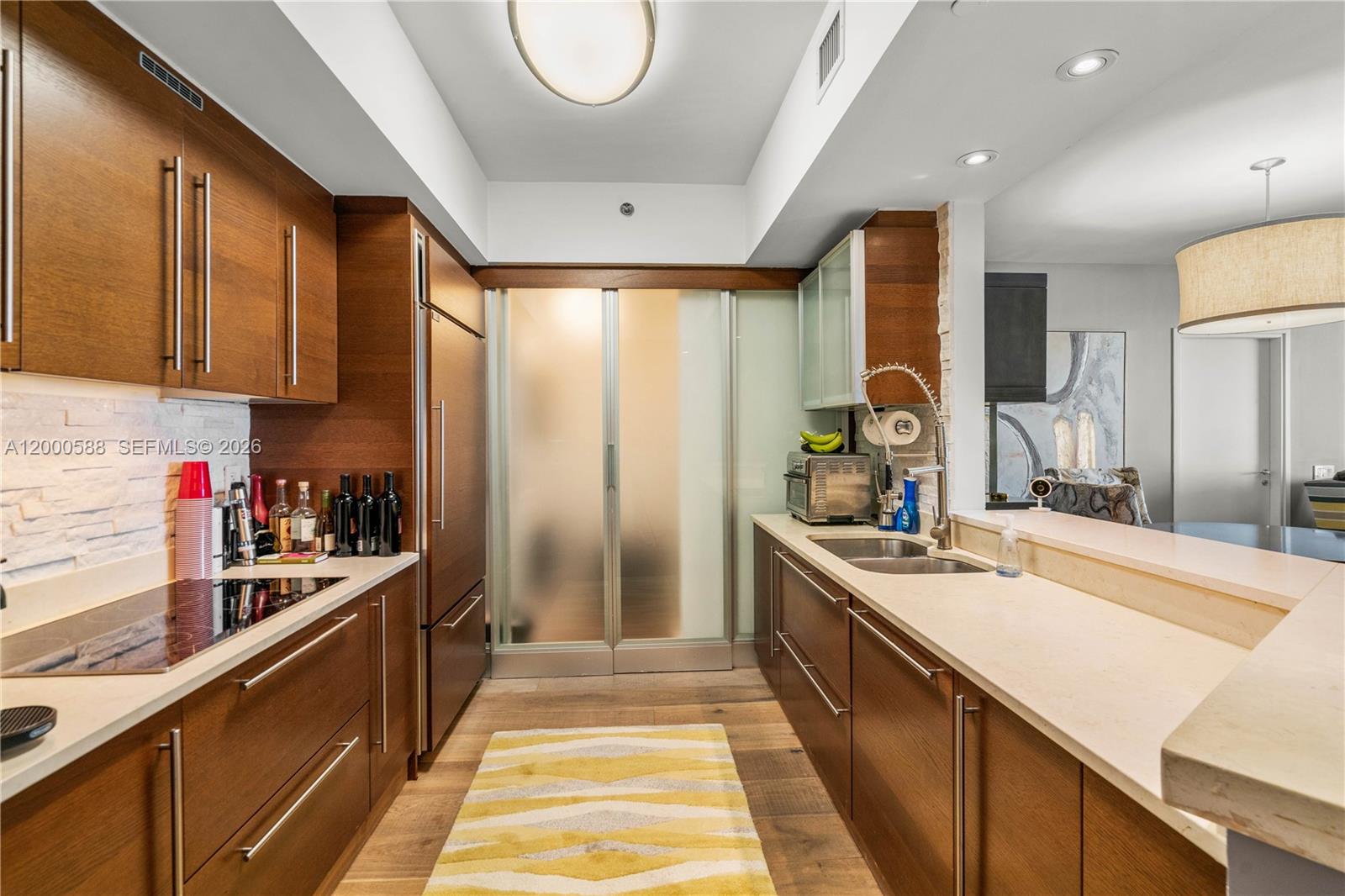 450 Alton Road, Unit 806 Miami Beach, FL 33139 - Photo 7 of 23 a large kitchen with stainless steel appliances granite countertop a sink and cabinets