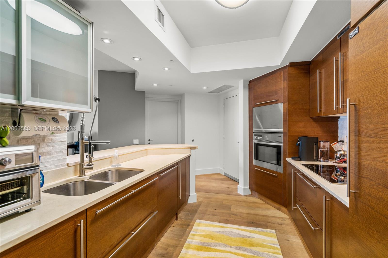450 Alton Road, Unit 806 Miami Beach, FL 33139 - Photo 10 of 23 a kitchen with stainless steel appliances a sink a stove and a refrigerator
