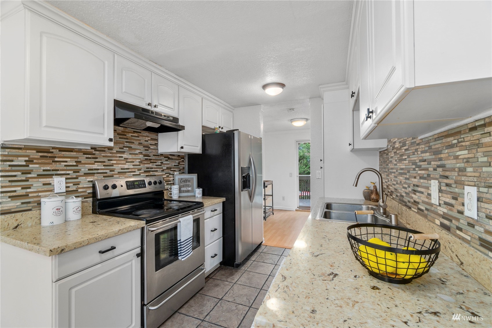 1800 Grant Avenue South, Unit D2 Renton, WA 98055 - Photo 6 of 23 a kitchen with stainless steel appliances granite countertop a stove a sink and a refrigerator