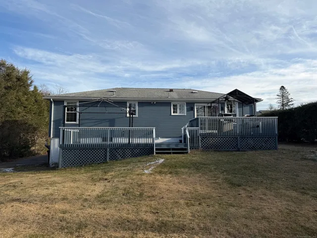 a view of a house with a backyard and a tree