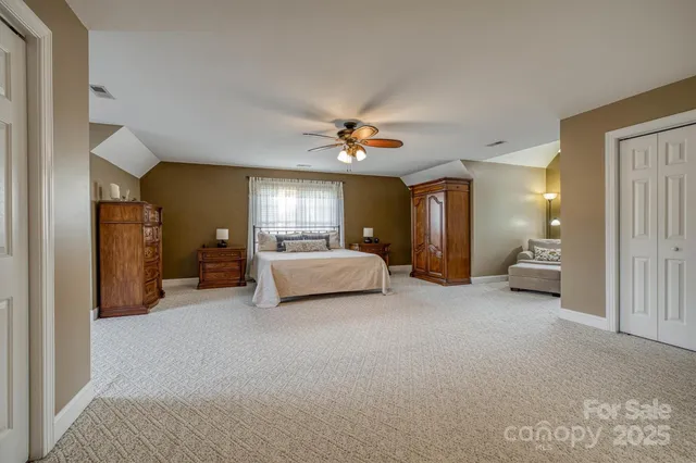 a spacious bedroom with a bed and a chandelier