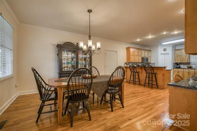 a view of a dining room with furniture a chandelier and wooden floor