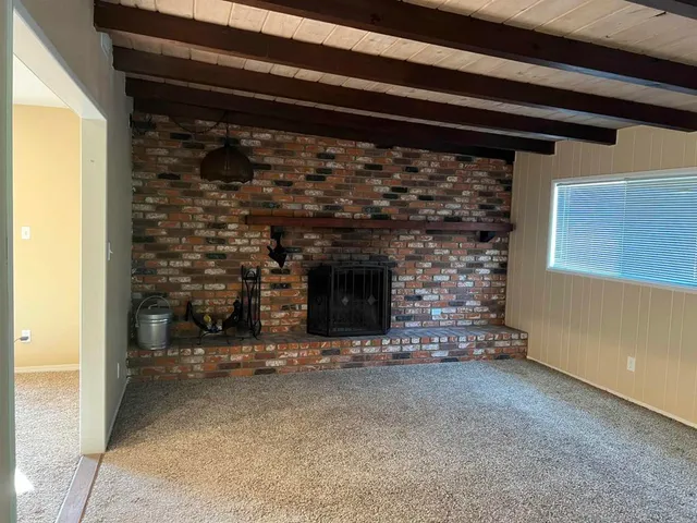 a view of empty room with fireplace and a window