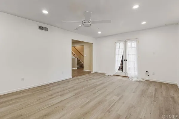 a view of empty room with wooden floor