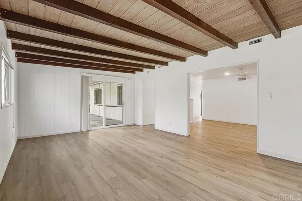 a view of empty room with wooden floor and fireplace