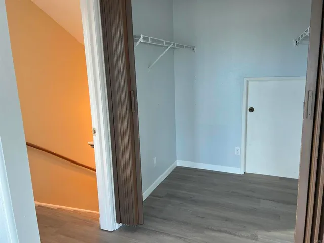 an entryway with wooden floor and a mirror