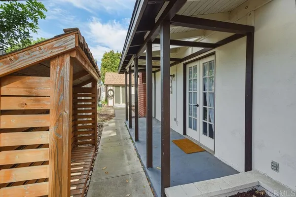 a view of a patio with table and chairs and floor to ceiling window