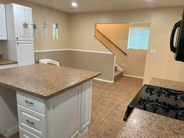 a kitchen with a sink a counter space and stainless steel appliances