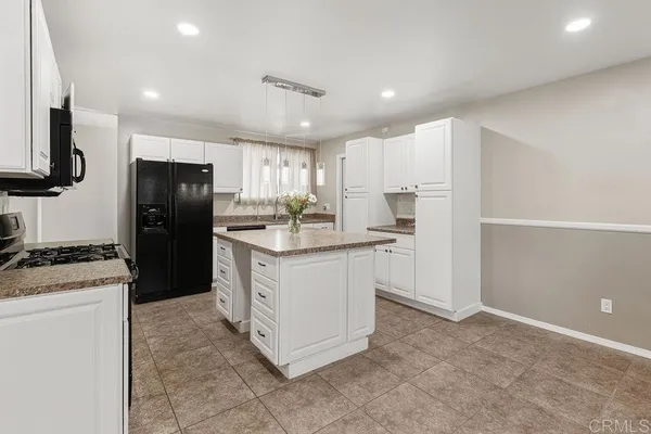 a kitchen with white cabinets and appliances