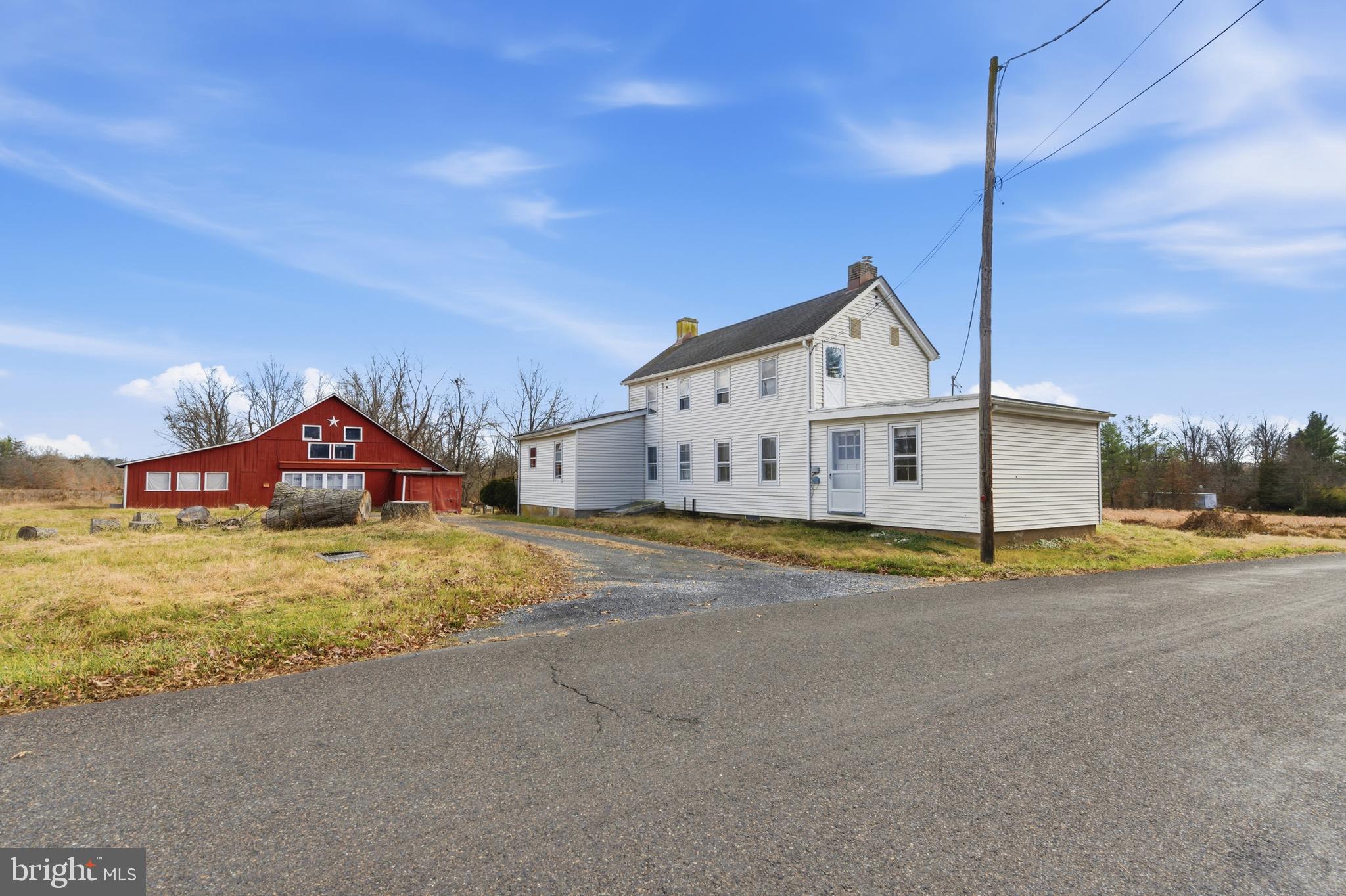 a view of a house with a big yard and large trees