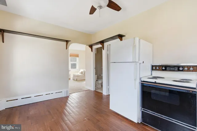 a kitchen with a refrigerator cabinets and wooden floor