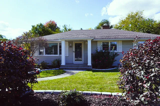 a view of a house with a yard and potted plants