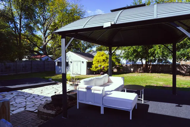 a view of patio with table and chairs under an umbrella