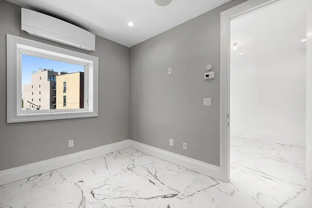 a view of a hallway to a room with a window