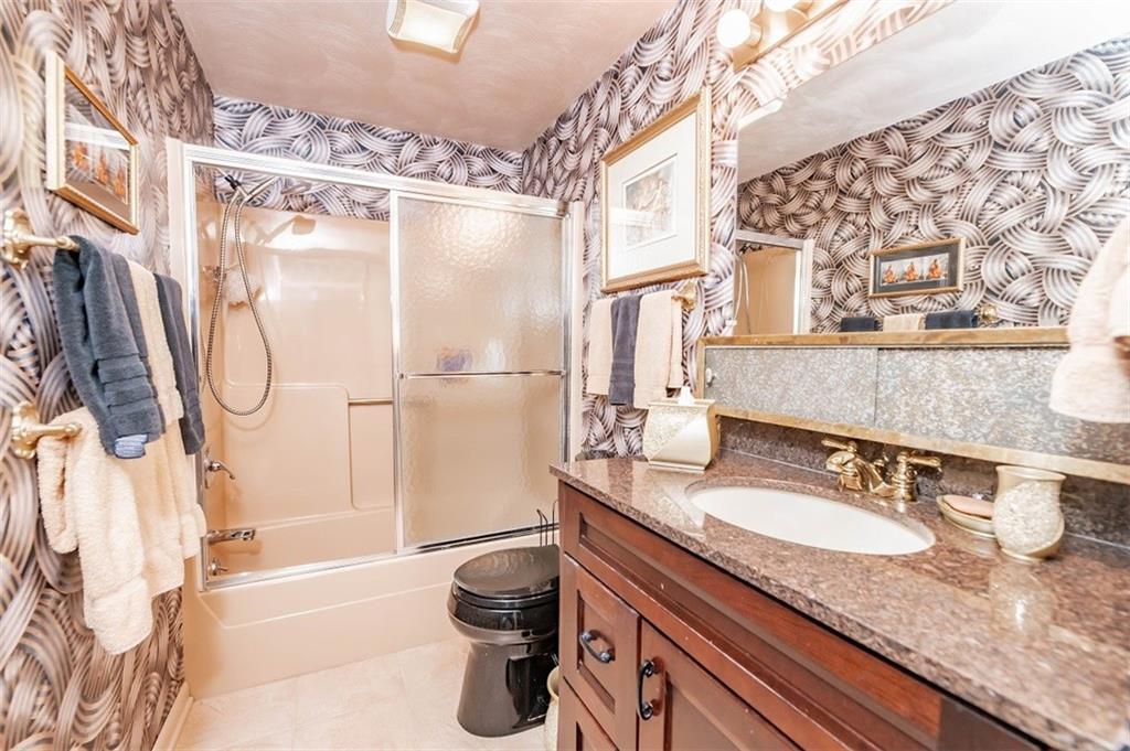 2740 Rebecca Street Indiana, PA 15701 - Photo 18 of 25 a bathroom with a granite countertop sink a mirror a bathtub and shower