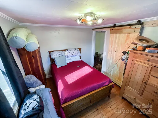 a bedroom with a bed and a mirror on the dresser