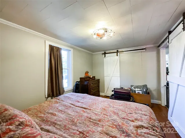 a bedroom with a bed and a chandelier