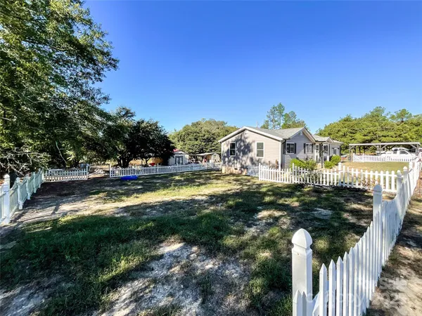 a view of a house with swimming pool next to a yard