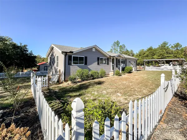 a view of a house with backyard and sitting area