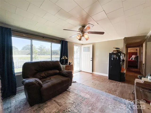a living room with furniture ceiling fan and a window
