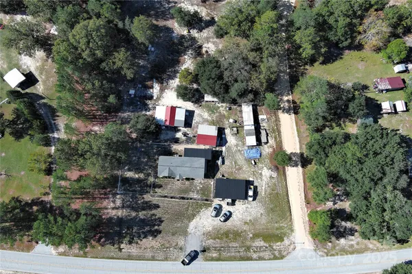 an aerial view of residential house with outdoor space and trees