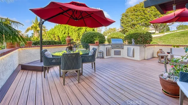 a view of a patio with couches table and chairs under an umbrella