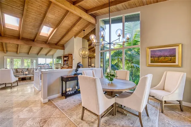 a dining room with furniture a rug a flat screen tv and outdoor view