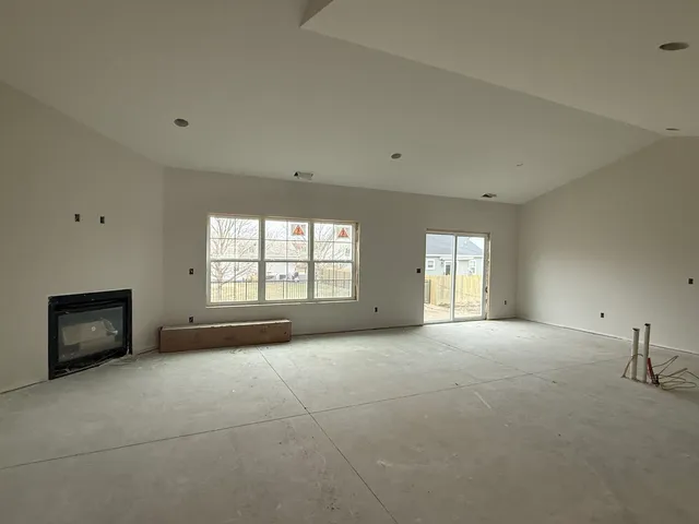 a view of an empty room with a window and fireplace