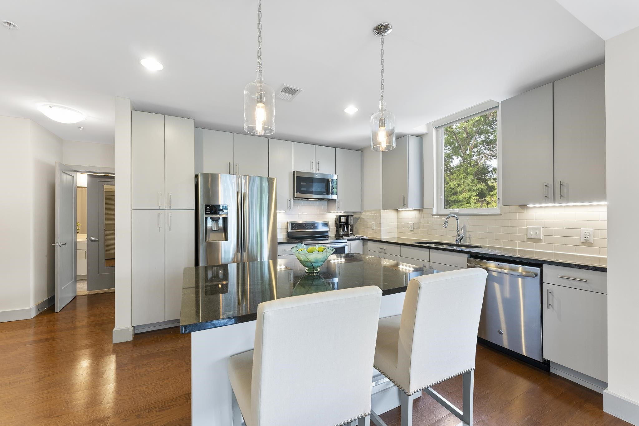 1300 St Marys Street, Unit 306 Raleigh, NC 27605 - Photo 13 of 30 a kitchen with kitchen island white cabinets and refrigerator