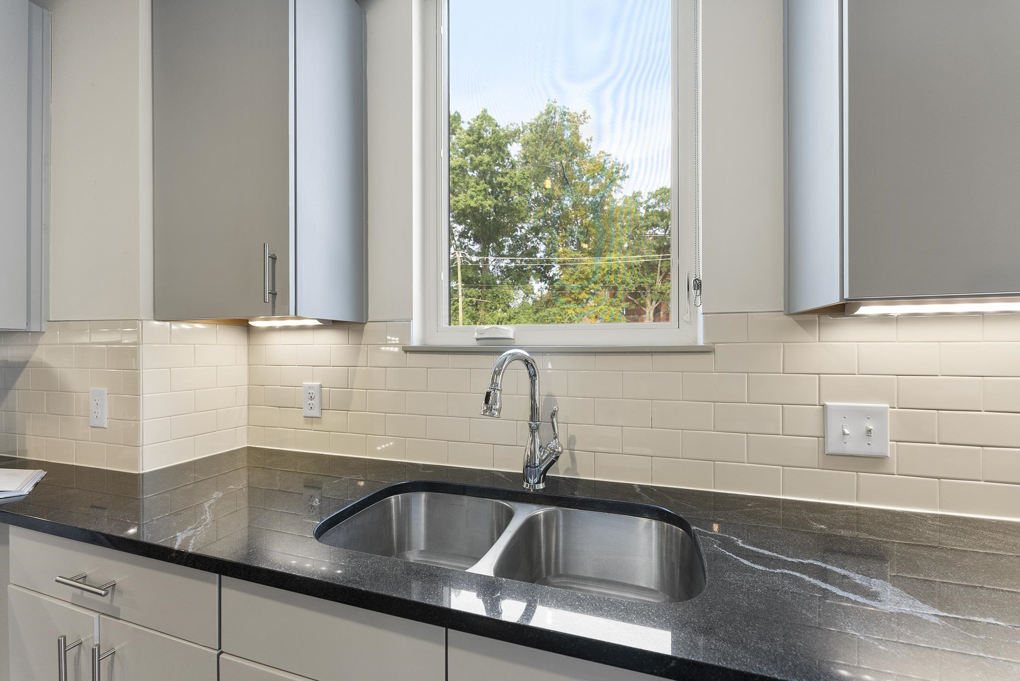 1300 St Marys Street, Unit 306 Raleigh, NC 27605 - Photo 16 of 30 a kitchen with granite countertop a sink and a window