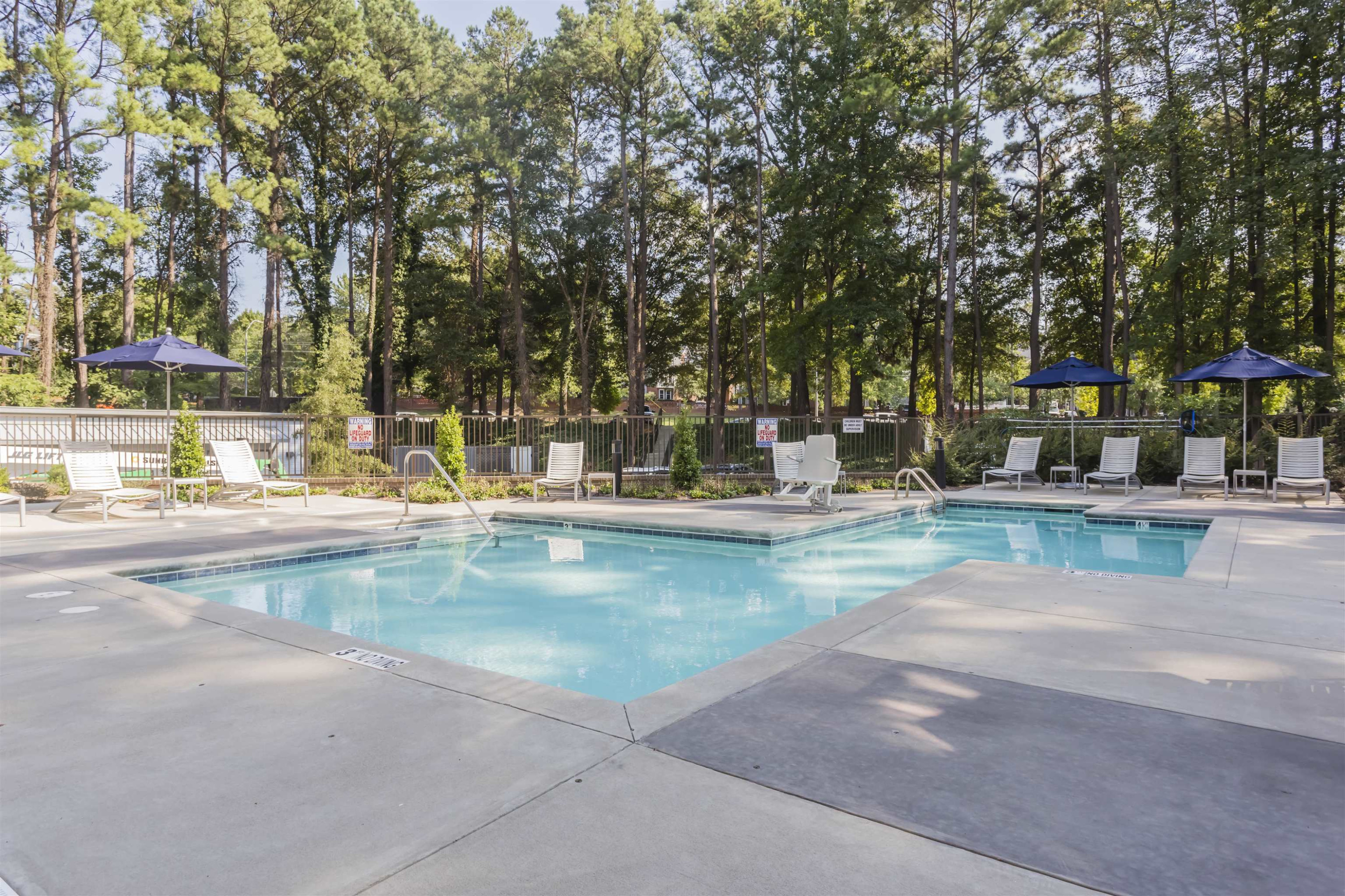 1300 St Marys Street, Unit 306 Raleigh, NC 27605 - Photo 29 of 30 a view of swimming pool with outdoor seating and trees in the background