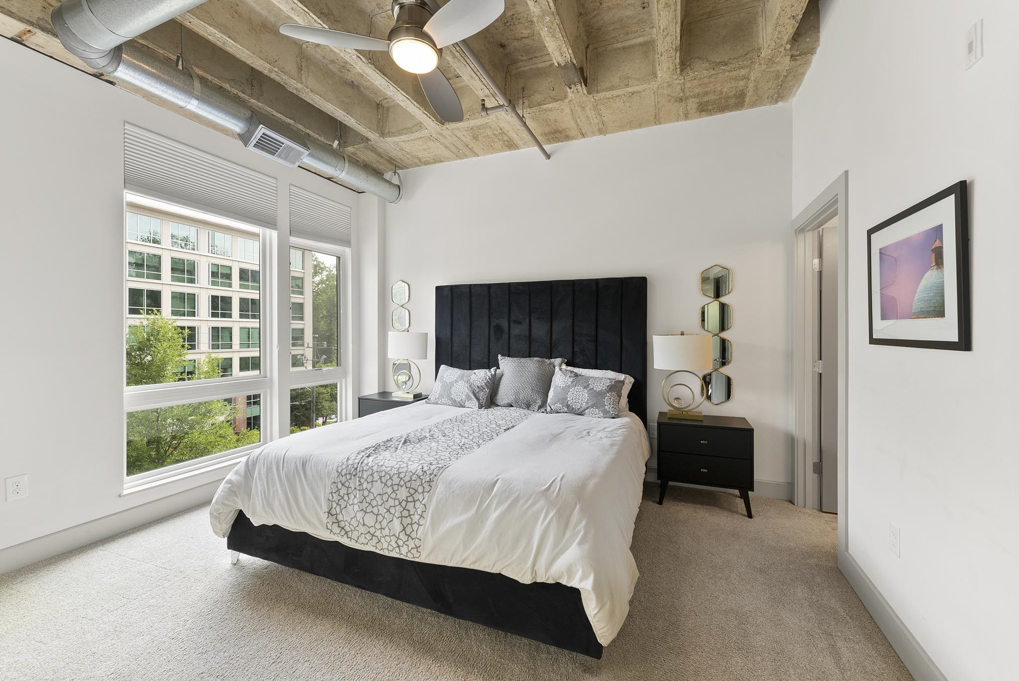 1300 St Marys Street, Unit 306 Raleigh, NC 27605 - Photo 5 of 30 a bed sitting in a bedroom next to a window