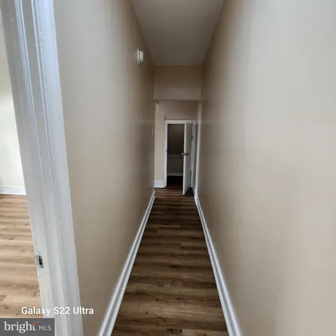 a view of a hallway with wooden floor and entryway