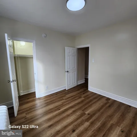 an empty room with wooden floor and mirror