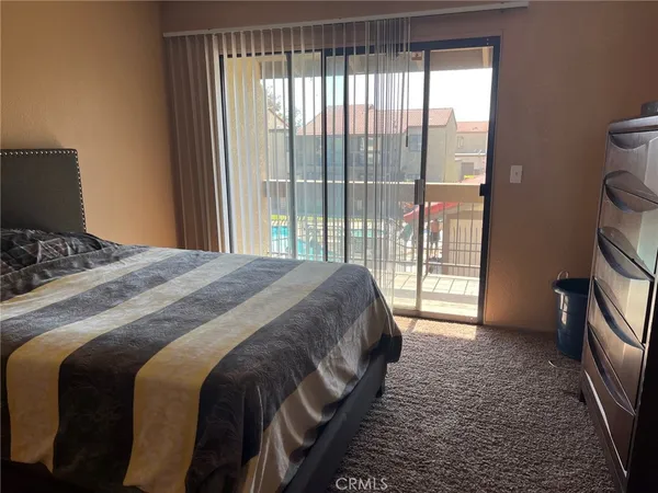 a bedroom with a bed and a large window
