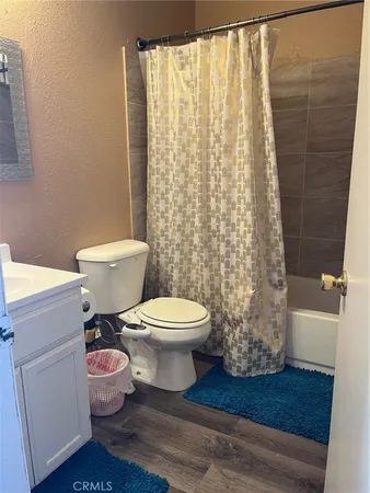 a white toilet sitting next to a shower curtain