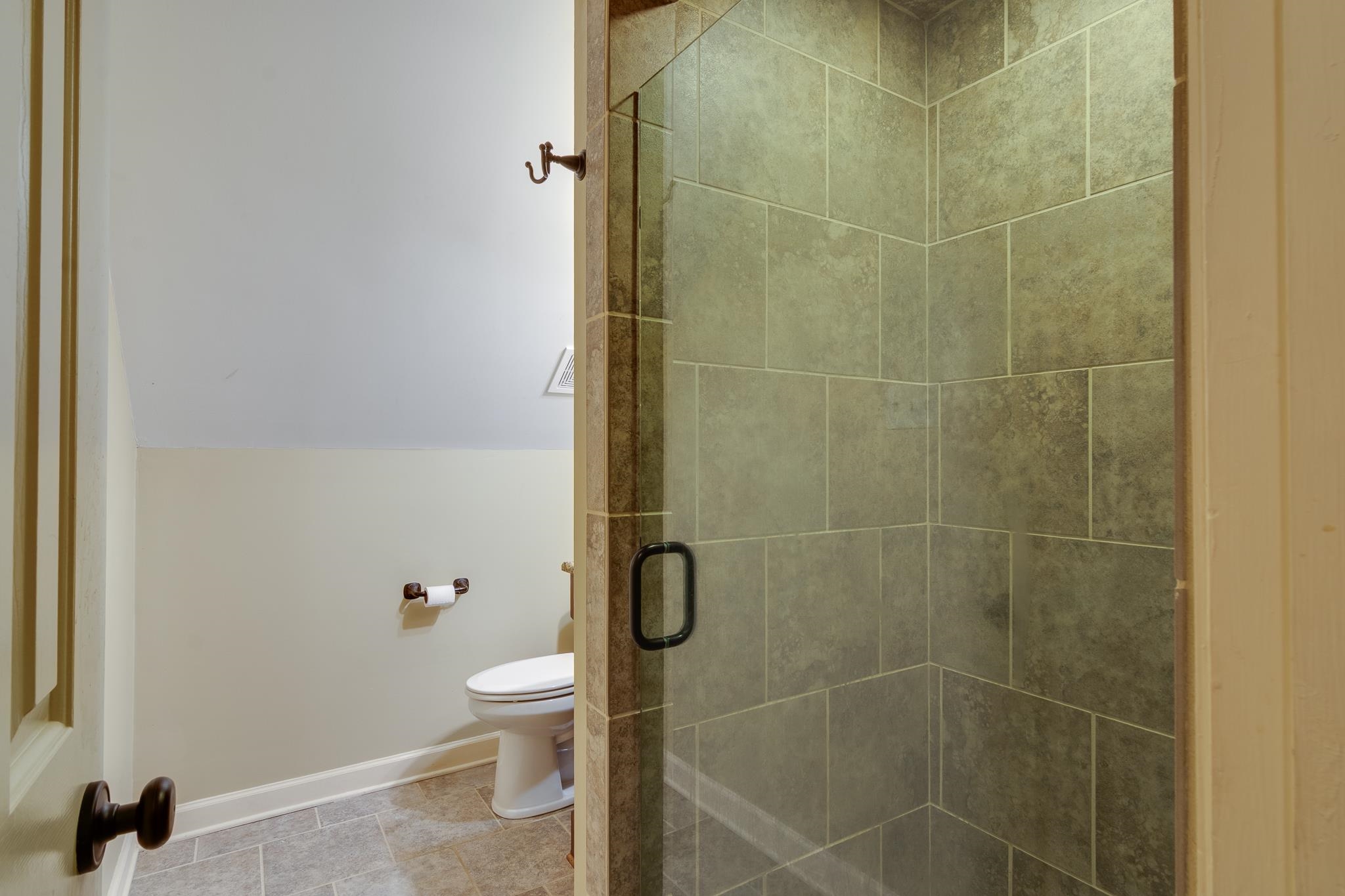 791 North Tree Drive Collierville, TN 38017 - Photo 23 of 27 Bathroom featuring a glass-enclosed shower with tile surround, a white toilet, and tile flooring