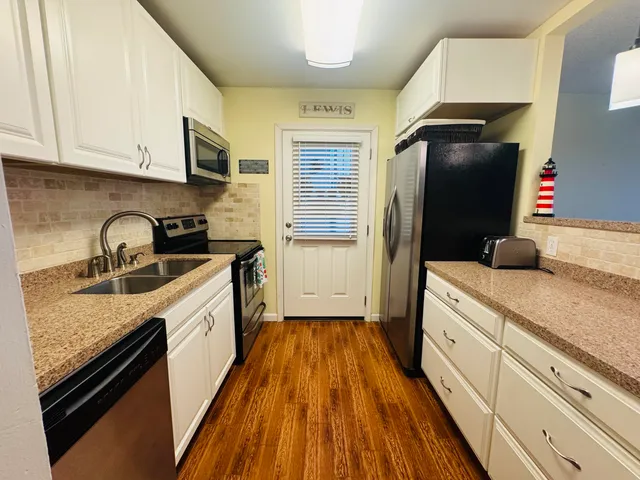a kitchen with a sink a refrigerator and cabinets