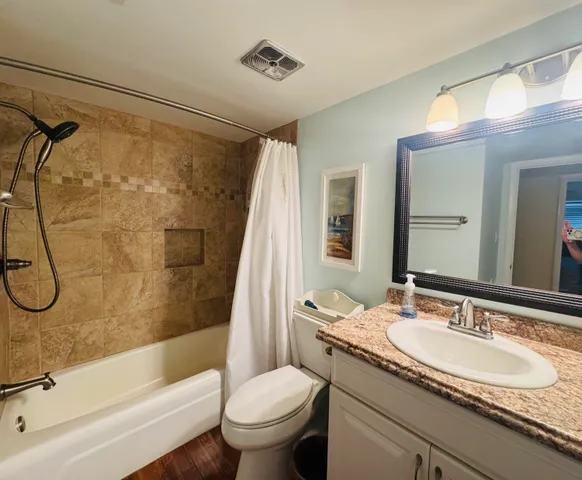 a bathroom with a granite countertop sink toilet and shower