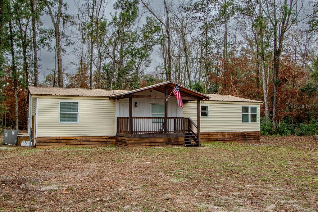 a view of a house with backyard and trees